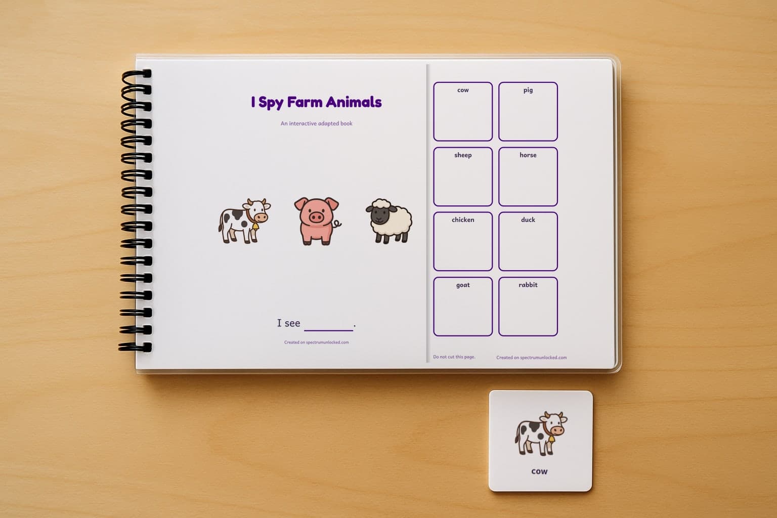 The I Spy Farm Animals adapted book closed on a table, its cover facing up, one picture card beside it