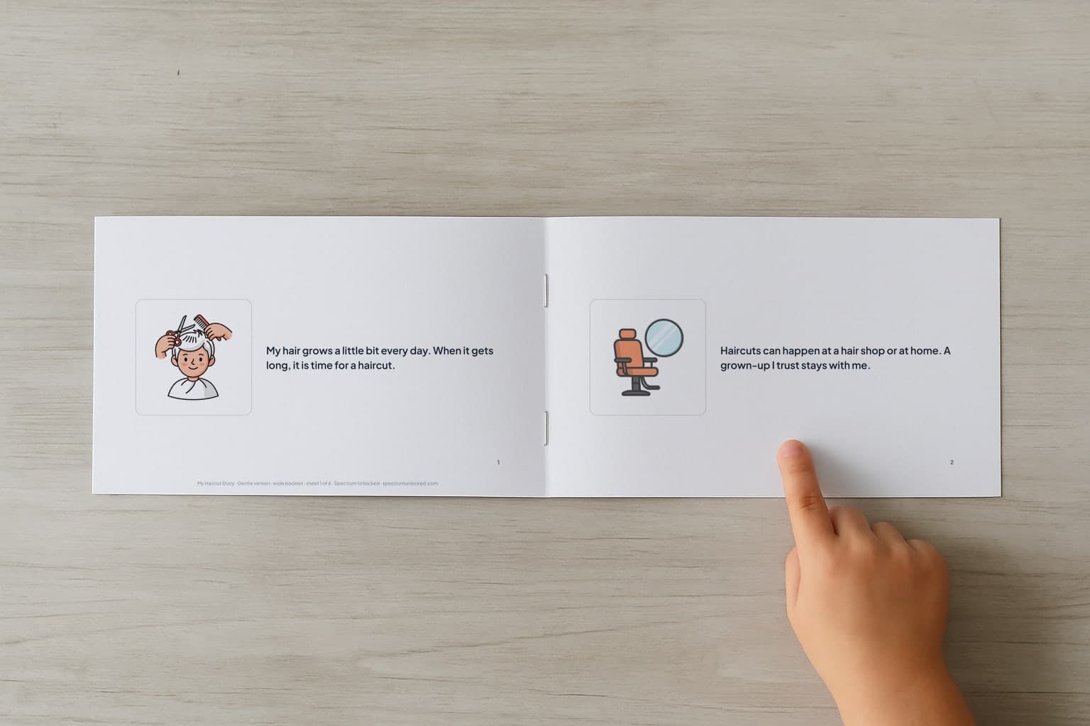 The Getting a Haircut social story booklet open to its first two pages, a child's finger pointing at the picture