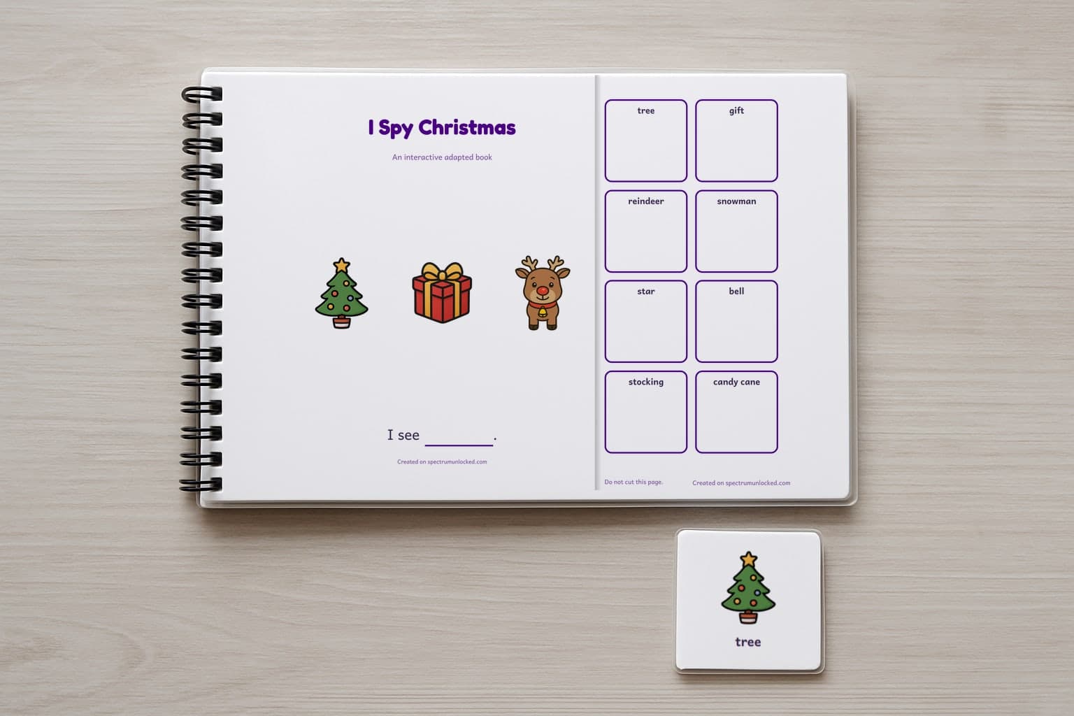 The I Spy Christmas adapted book closed on a table, its cover facing up, one picture card beside it
