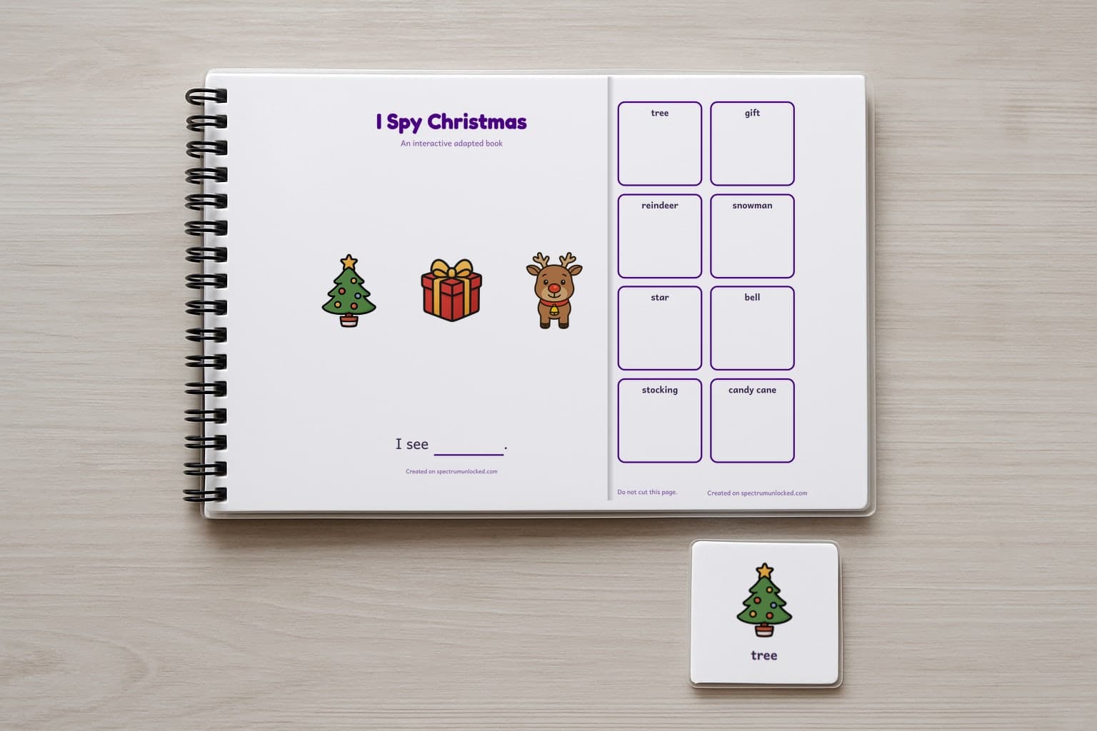 The I Spy Christmas adapted book closed on a table, its cover facing up, one picture card beside it