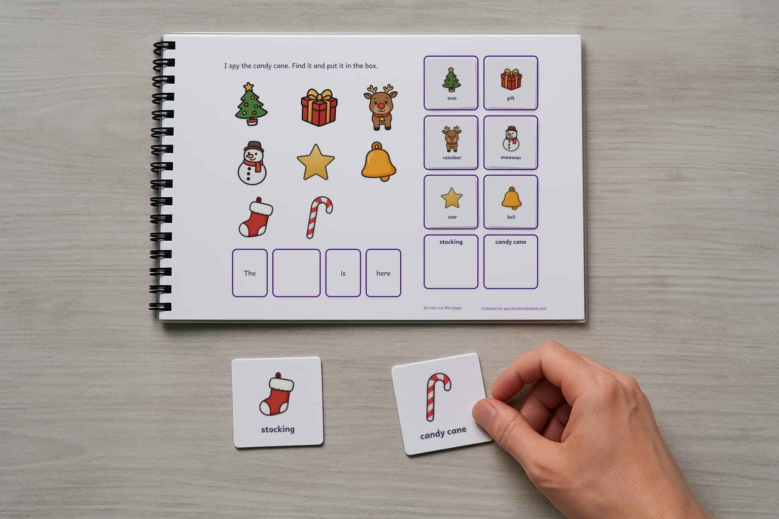 The I Spy Christmas adapted book with its picture cards stored on the choice column, the last two loose on the table
