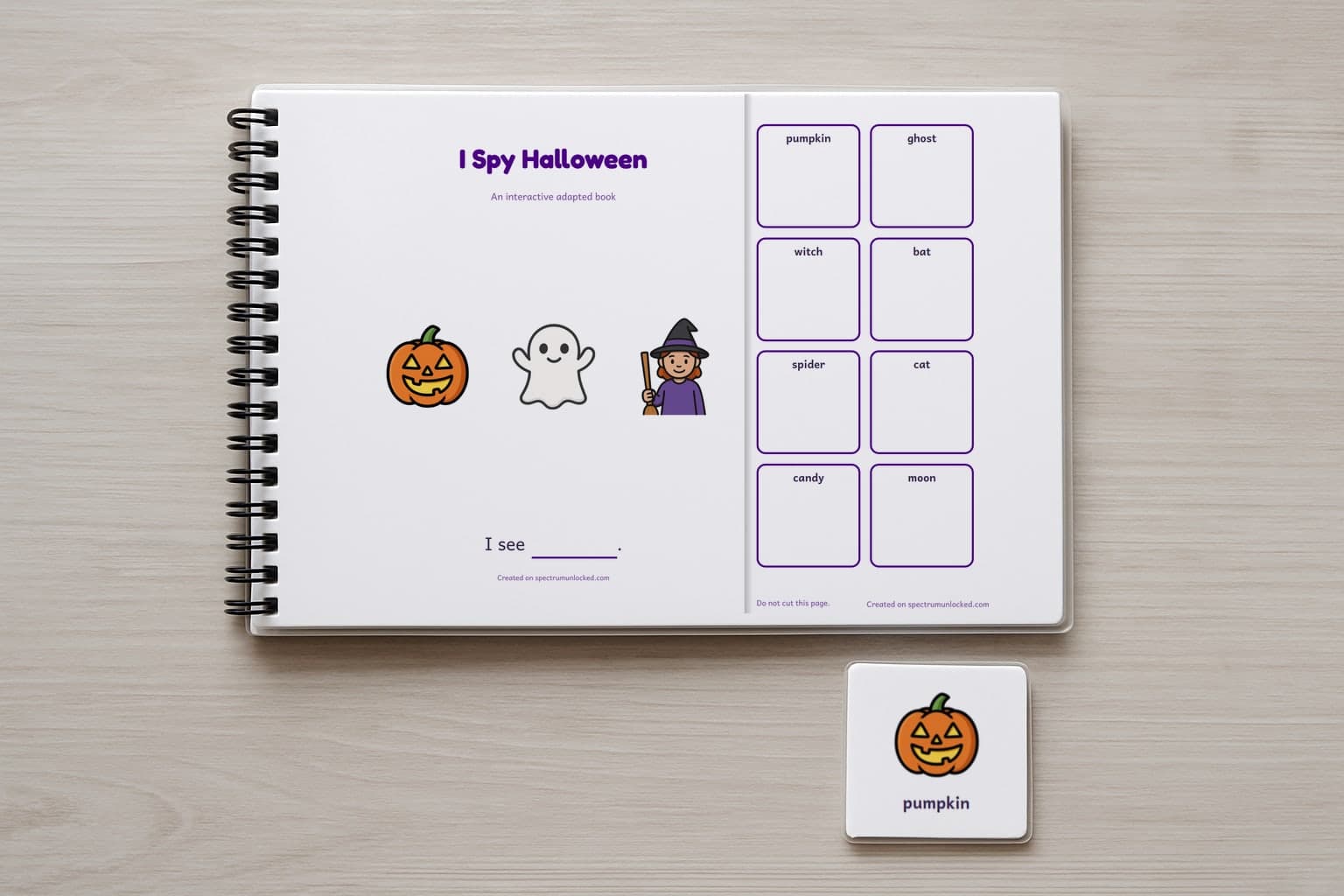 The I Spy Halloween adapted book closed on a table, its cover facing up, one picture card beside it
