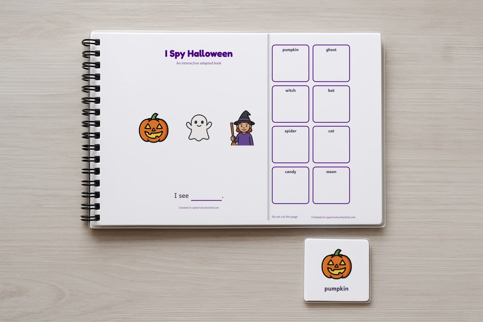 The I Spy Halloween adapted book closed on a table, its cover facing up, one picture card beside it