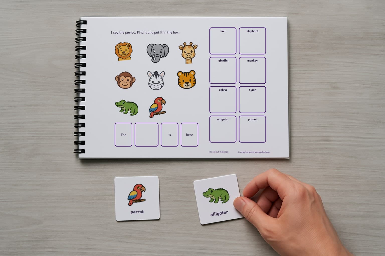 The last page of the I Spy Zoo Animals adapted book with its choice column, two picture cards resting beside it