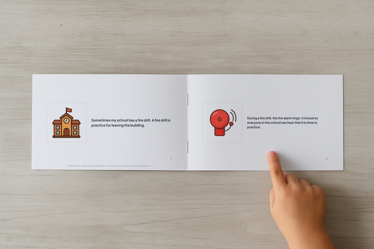 The Fire Drill social story booklet open to its first two pages, a child's finger pointing at the picture
