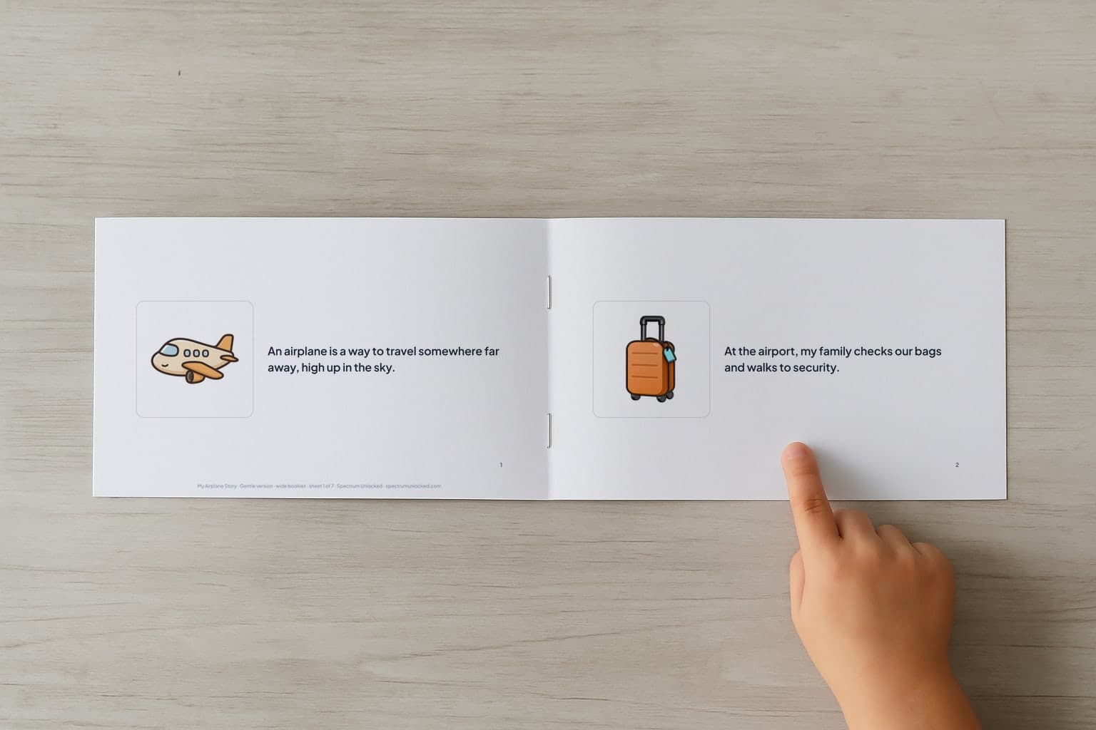The Flying on a Plane social story booklet open to its first two pages, a child's finger pointing at the picture