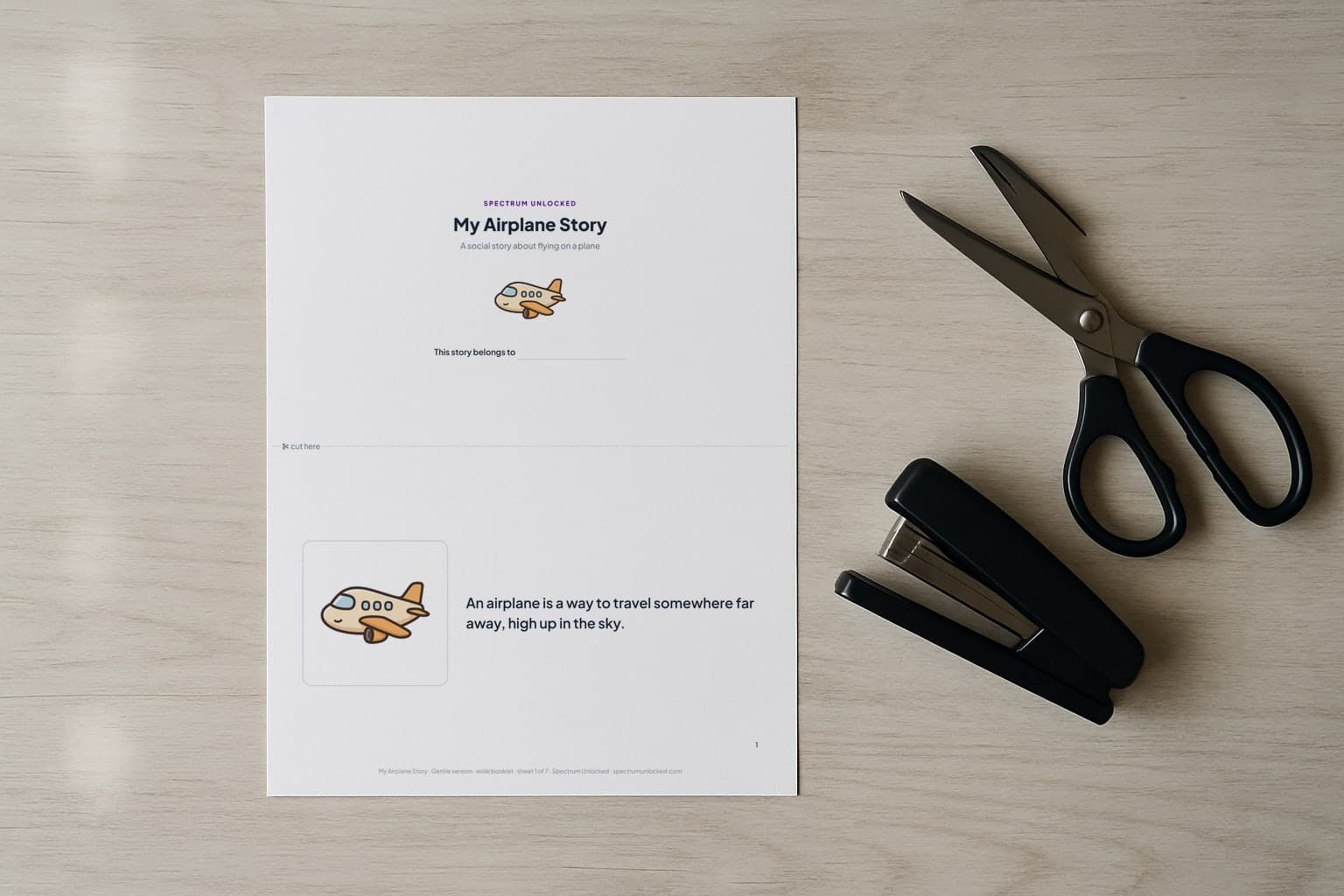 The Flying on a Plane social story printed two pages to a Letter sheet, scissors and a stapler beside it before the cut