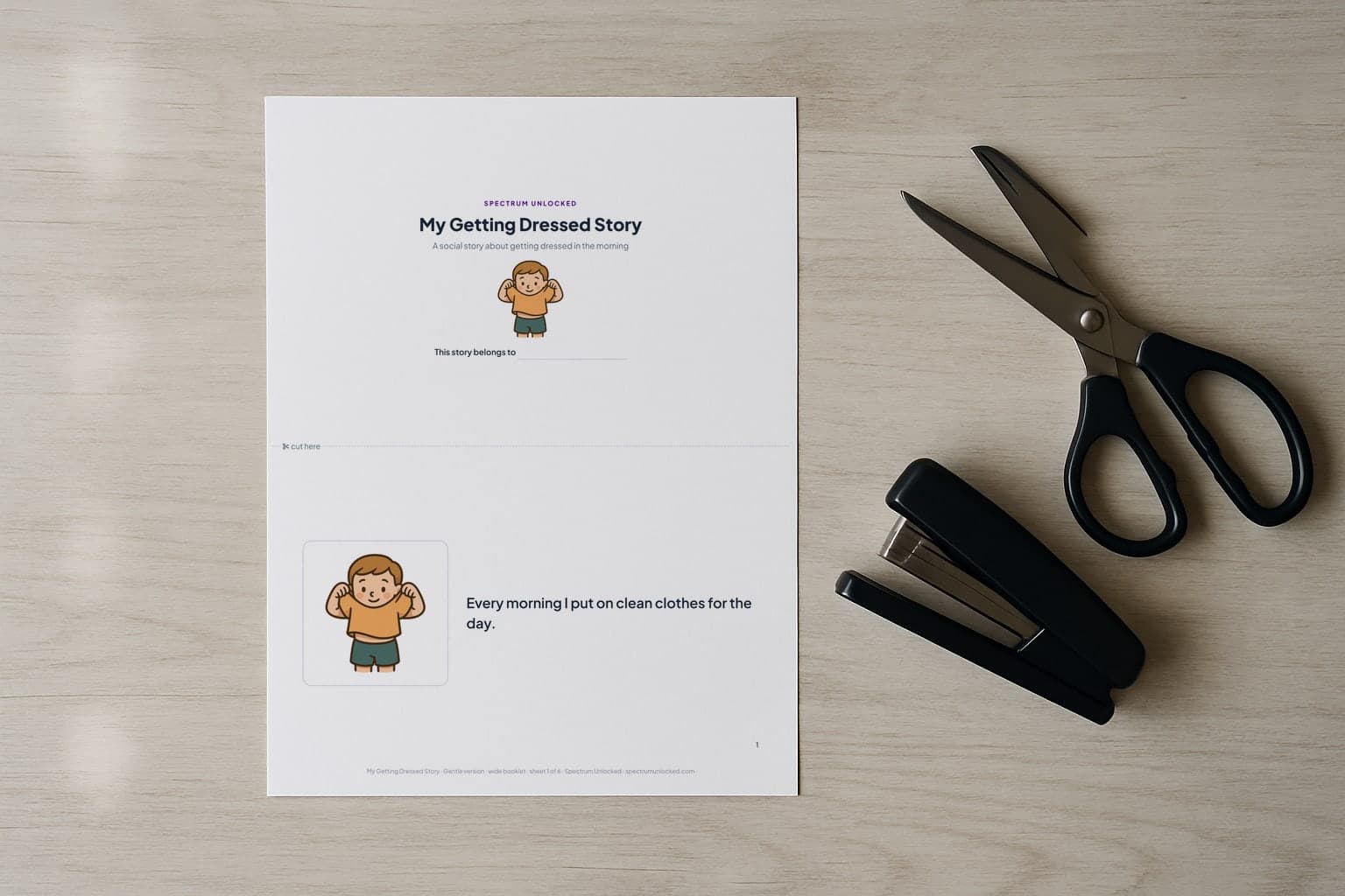 The Getting Dressed social story printed two pages to a Letter sheet, scissors and a stapler beside it before the cut