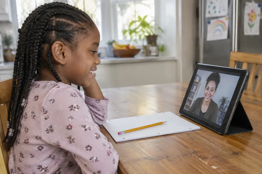 A child in a tutoring session on a tablet at home